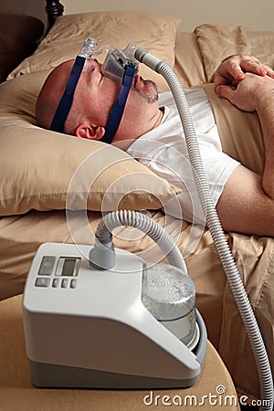 Man with sleep apnea using a CPAP machine