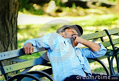 Man is sleeping on a bench in New-York.