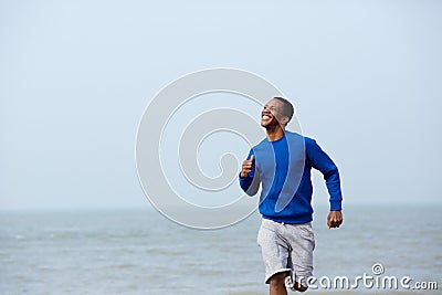 Man smiling and jogging outdoors