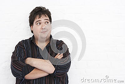 Man standing against wall with Arms Crossed looking to left port