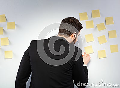 Man standing next to a wall with postits