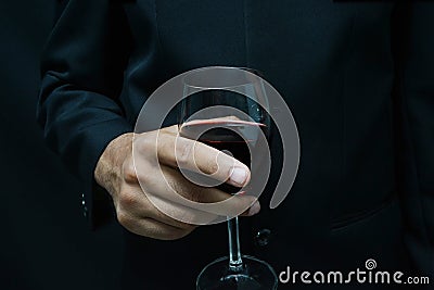 Man in suit holding glass of wine