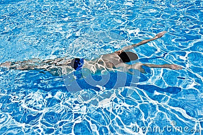 Man swimming underwater in pool