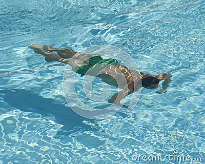 Man swimming underwater in pool