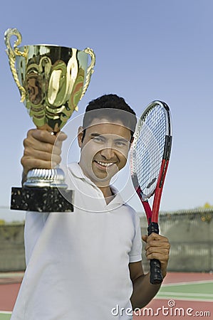 Man on tennis court Holding Trophy