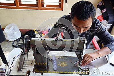 Man Tibetan sew cotton by Sewing machine at Tibetan Refugee Camps