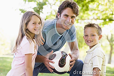 Man and two children outdoors holding volley