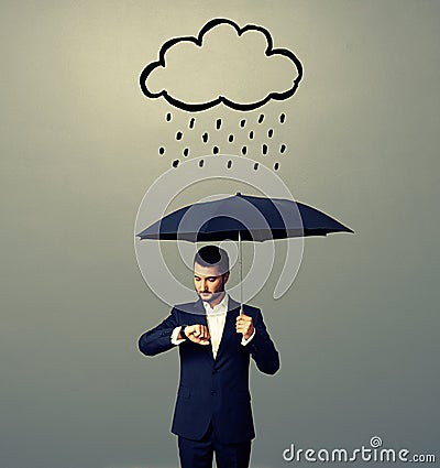 Man with umbrella looking at watch