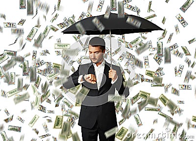 Man under money rain looking at watch