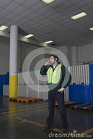 Man Using Cellphone In Factory