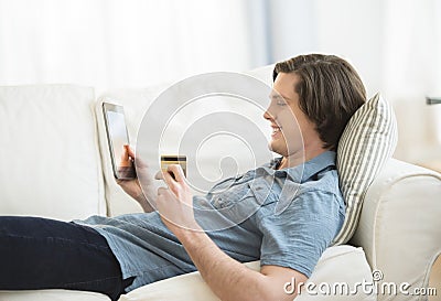 Man Using Credit Card To Shop Online On Digital Tablet