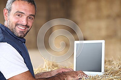 Man using laptop on a farm