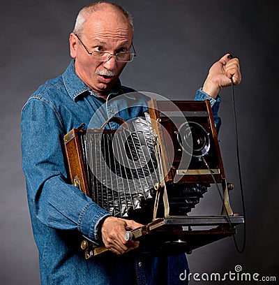 Man with vintage wooden photo camera