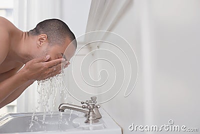 Man Washing Face In Sink