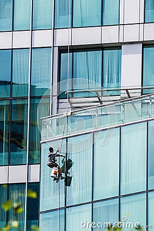 Man washing windows on a glass skyscraper