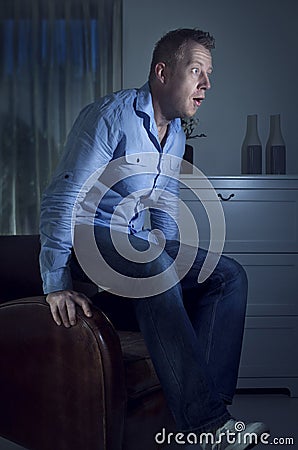 Man watching TV jumps up