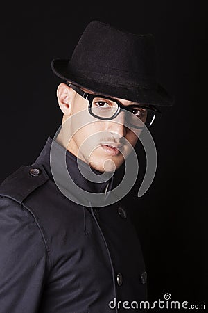 Man wearing hat, glasses and black coat