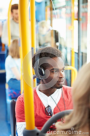 Man Wearing Headphones Listening To Music On Bus Journey