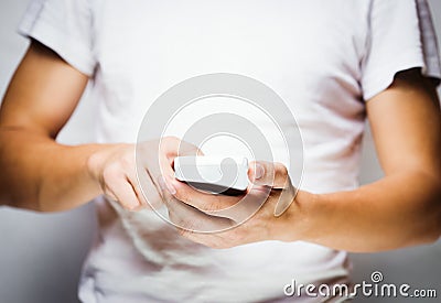 Man in white t-shirt using mobile smart phone