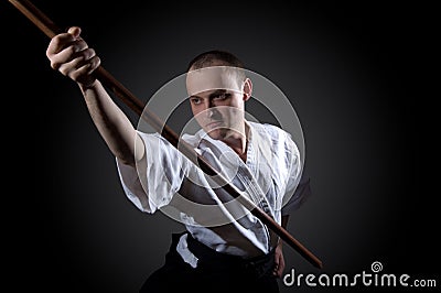 Man in white with wooden sword