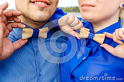 Man and woman in blue shirts with wooden bow tie