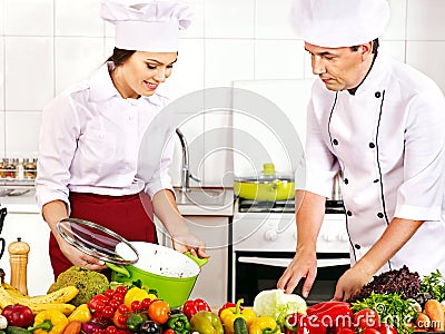 Man and woman in chef hat cooking.