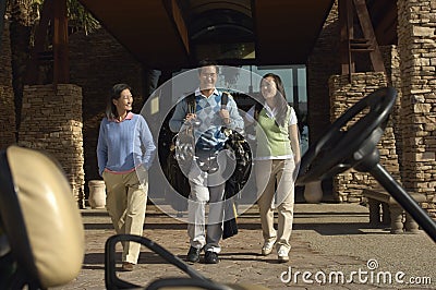 Man With Women Carrying Golf Bags