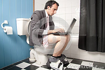 Man working with a laptop in WC
