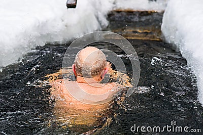 A man in years swims in the ice hole