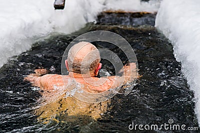 A man in years swims in the ice hole