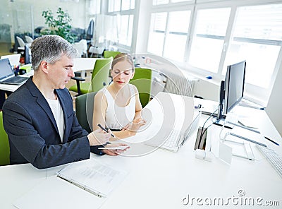 Manager giving order to assistant in office