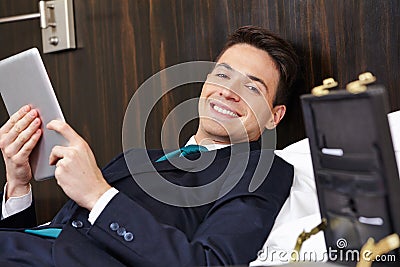 Manager using tablet computer in hotel bed