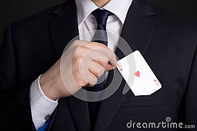 Mans hand hiding playing card in suit pocket