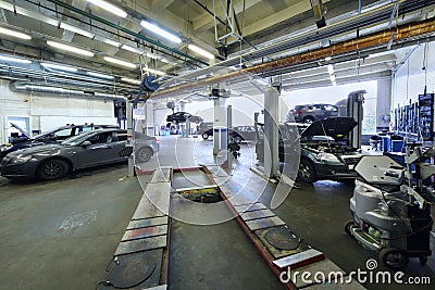 Many cars stand in car garage with special equipment