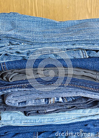 Many jeans on sandy brown background close-up