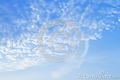 Many small puffy white clouds in blue sunrise sky