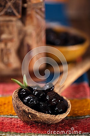 Marinated Olives in old spoon with moroccan ornament on wood