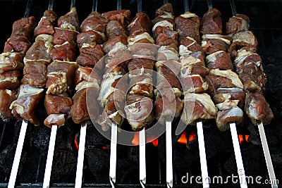 Marinated, raw lamb meat grilling on metal skewer