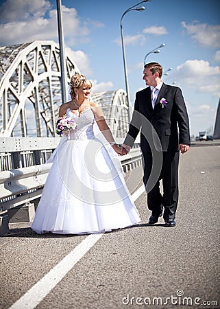 Married couple holding hands and walking on road