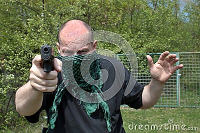 Masked man aims with gun