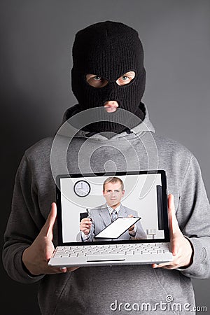 Masked man with laptop - concept picture of internet crime