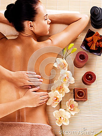 Masseur doing massage on woman back in spa salon