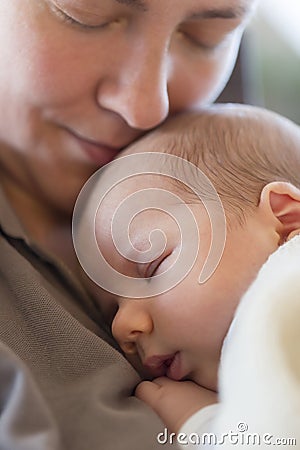 Maternal affection: Peaceful baby boy sleeping on mother s chest