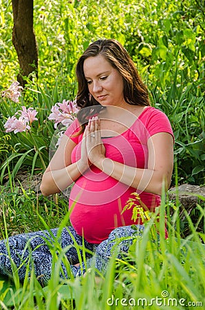 Maternity Yoga peaceful meditation in field of flowers.