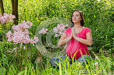 Maternity Yoga peaceful meditation in field of flowers.