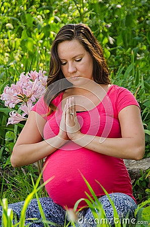 Maternity Yoga peaceful meditation in field of flowers.