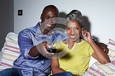 Mature African American Couple On Sofa Watching TV Together