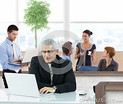 Mature businessman working in office hallway