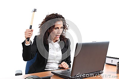 Mature businesswoman trying to destroy a laptop with a hammer