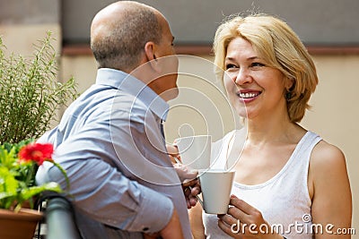 Mature couple on balcony with coffee